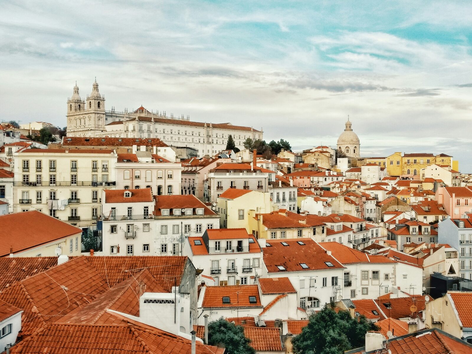 Red tile roofs of Alfama climbing to the towers of Sao Vicente de Fora in Lisbon