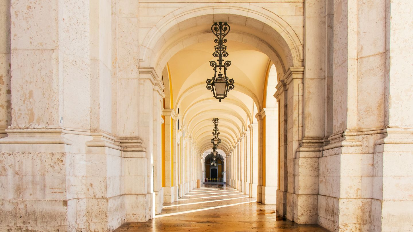 A long stone arcade in Lisbon, lit end to end