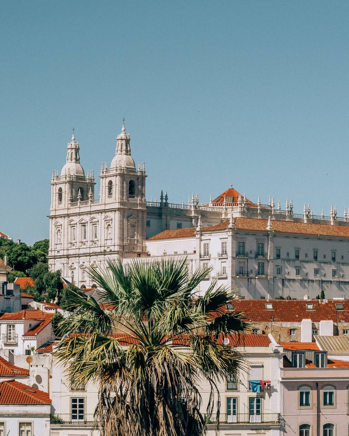 The white twin towers of Sao Vicente de Fora above the red roofs of Alfama in Lisbon